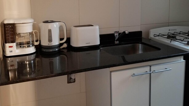 A kitchen with a coffee maker, toaster, and stove.