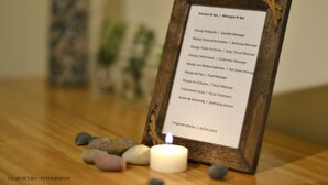 A wooden framed menu listing various massage services.