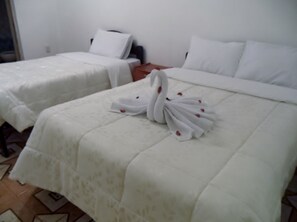 Une chambre d’hôtel avec deux lits, chacun agrémenté de draps blancs et d’une serviette décorative en forme de cygne.