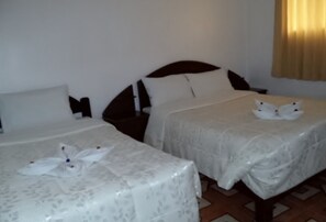 A hotel room with two beds, each with a white floral bedspread and a decorative pillow. - Cusco Gran Hostel & Vacations (Cusco)