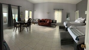 A hotel room with a dining area, a sofa, a bed, and a window with curtains. - All Year Lakefront Getaway in a private guest rm & indoor heated pool !! (Westport)