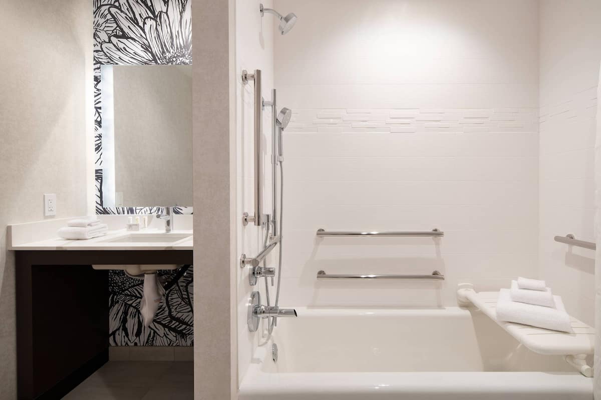 Un baño moderno con un lavamanos blanco, una bañera y una ducha.