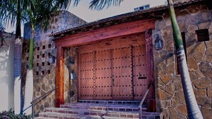 Un bâtiment en pierre avec une porte en bois et des marches menant à l’entrée.