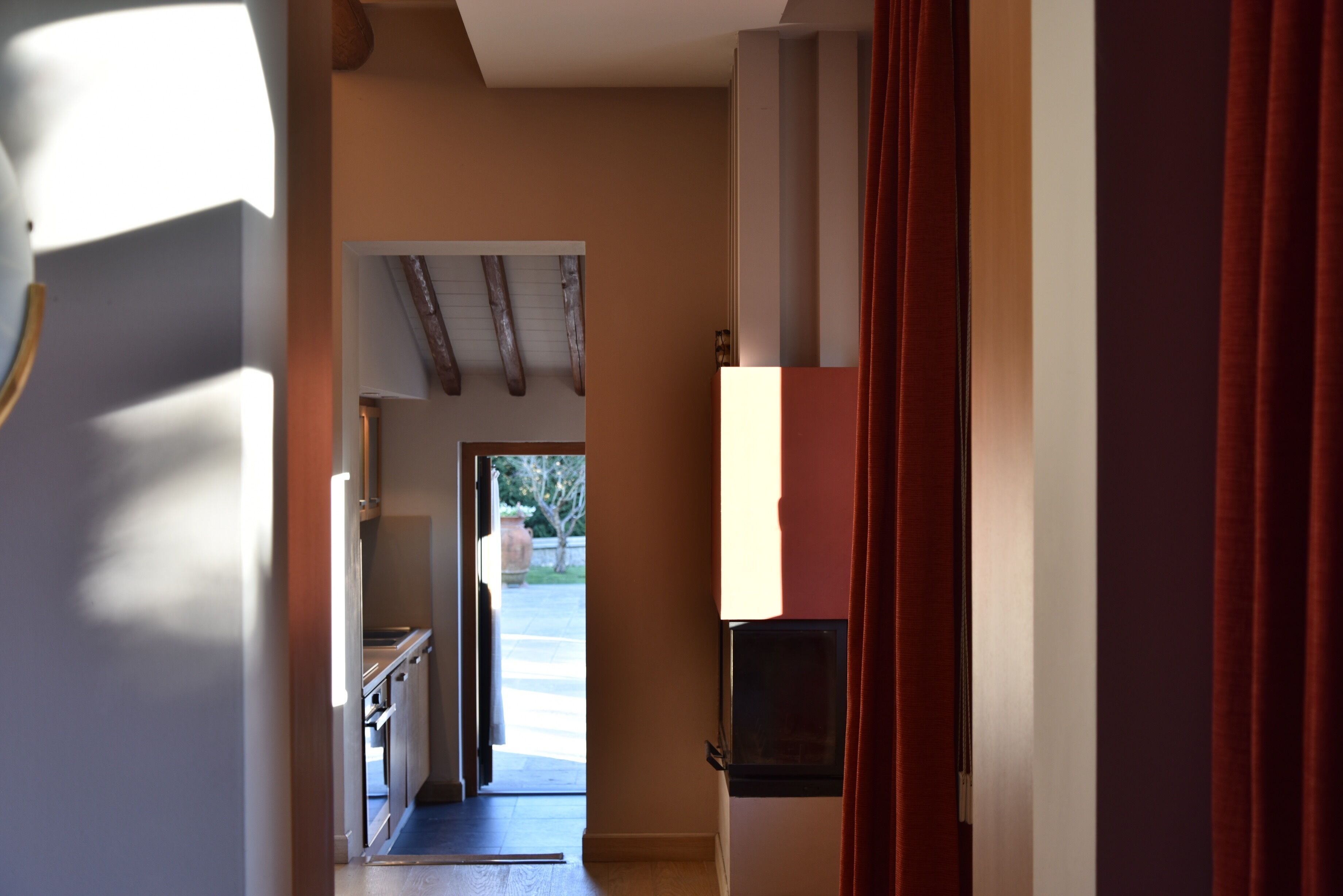 Un couloir avec une porte donnant sur un espace cuisine.