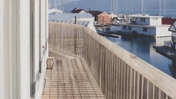 A balcony with a view of a marina and mountains.