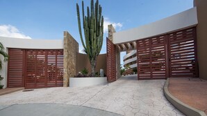 A modern building with a large cactus in the center, surrounded by a paved courtyard with hexagonal tiles. - Punta Arrocito D202 (Santa María Huatulco)