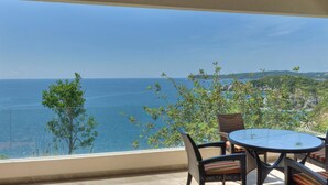 A balcony with a view of the sea, wicker furniture, and a ceiling fan. - Punta Arrocito D202 (Santa María Huatulco)