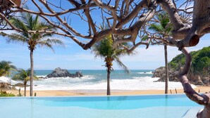 Una piscina con vista al océano y a la costa rocosa.