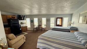 A compact room with a kitchenette, a bed, a sofa, and a dining area. - Scenic Bay Motel room 2 (Bayview)