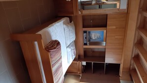 A compact room with a bed, a small table, and a window. - Chalet 1 to 5 persons garden and terrace with pergola in residential park (Soulac-sur-Mer)