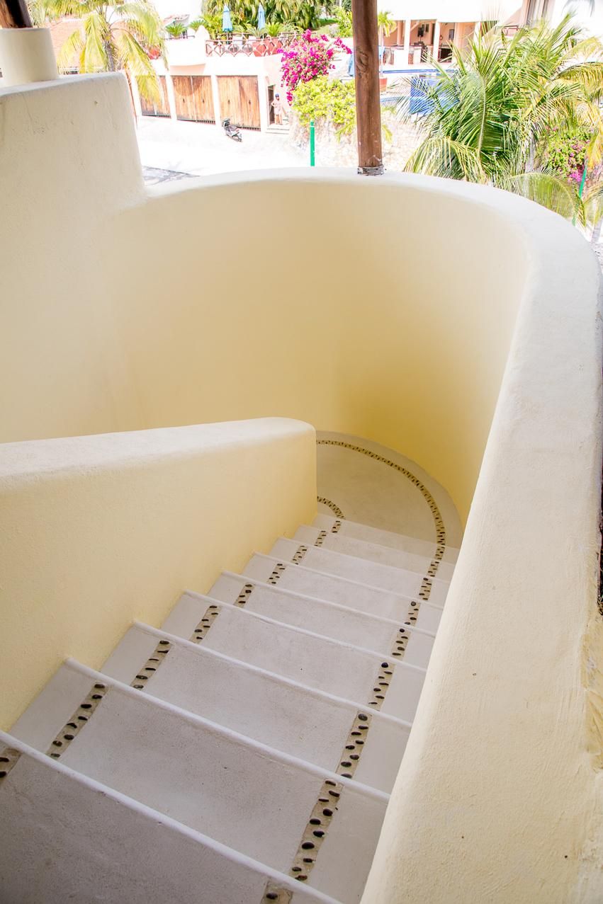 A white staircase with a curved design, leading to an upper level.