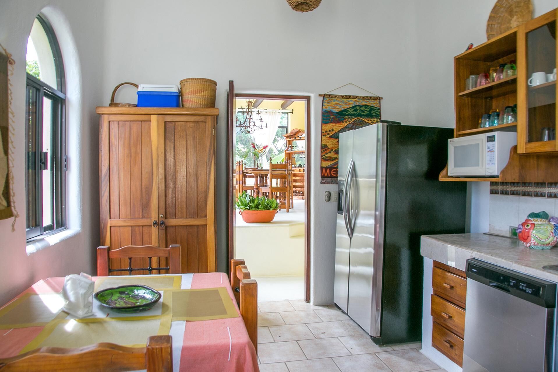 A compact kitchen with a refrigerator, microwave, and wooden cabinets.