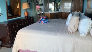 A bedroom with a large bed, a dresser, a mirror, and a window. - New listing!  Amazing sunrises and ocean views (St John)