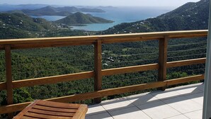 A wooden deck with a bench overlooking a mountainous landscape with a lake and distant hills. - New listing!  Amazing sunrises and ocean views (St John)