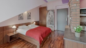 Ein Schlafzimmer mit einem hölzernen Bett, einer roten Decke, einem Nachttisch, einer Wandlampe und einem Blumentopf.