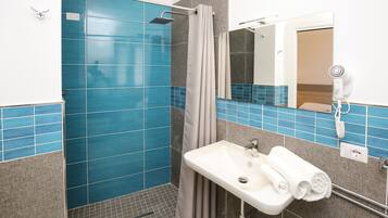 Une salle de bain avec une douche, un lavabo et un miroir.