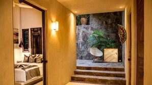 A staircase leading to a bedroom with a stone wall and a potted plant. - Villa Maroma (Santa María Huatulco)
