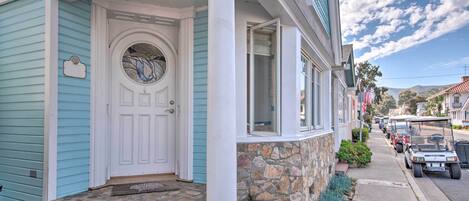 A house with a stone porch, a white door, and a blue exterior.