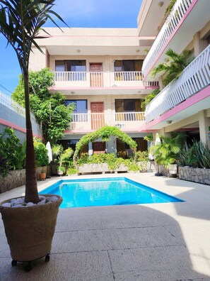 Relax by the central pool surrounded by lush greenery and beautifully landscaped gardens.