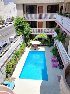 Relax by the rooftop pool surrounded by lush greenery.