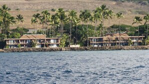 Il s'agit d'une propriété située en bord de mer, comprenant deux bâtiments, chacun doté de balcons et séparé de l'océan par un mur de pierre.