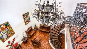 A spiral staircase with ornate metal railings and a chandelier. - Room "El Guayabo" Caroline Bella  (Ajijic)