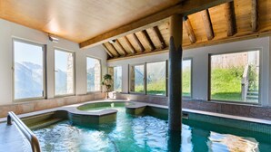 A spa area with a hot tub and a small pool, large windows, and a wooden ceiling. - Piscine + Casiers à Ski | 50m des Remontées ! (Saint-Lary-Soulan)