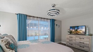 A bedroom with a bed, a dresser, a ceiling fan, a window with curtains, and a painting on the wall. - 🌴 Great escape with private heated pool LOOK INSIDE  (Port Richey)
