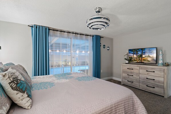 A bedroom with a bed, a dresser, a ceiling fan, a window with curtains, and a painting on the wall. - 🌴 Great escape with private heated pool LOOK INSIDE  (Port Richey)