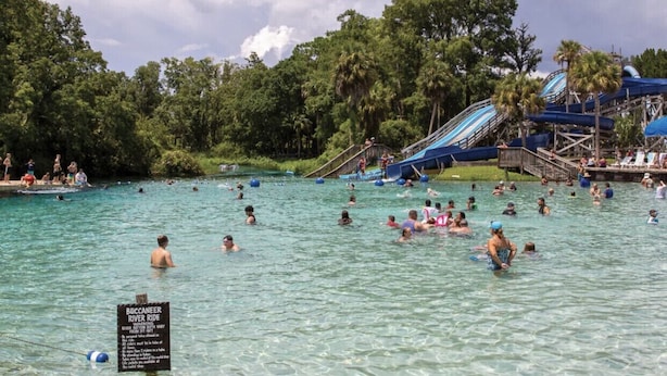 A water park with clear water, a river ride sign, and people swimming and enjoying the area. - 🌴 Great escape with private heated pool LOOK INSIDE  (Port Richey)