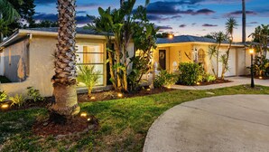 A residential house with a well-maintained lawn, a palm tree, and a welcoming entrance. - 🌴 Great escape with private heated pool LOOK INSIDE  (Port Richey)