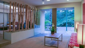 A modern interior with a glass wall, bamboo decor, a ceiling fan, and a view of greenery outside. - Villamar 101 (Santa María Huatulco)