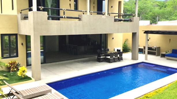 A modern two-story house with a swimming pool, outdoor seating, and a covered patio area. - Casa Medina (Santa María Huatulco)