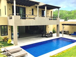 A modern two-story house with a swimming pool, outdoor seating, and a covered patio area. - Casa Medina (Santa María Huatulco)
