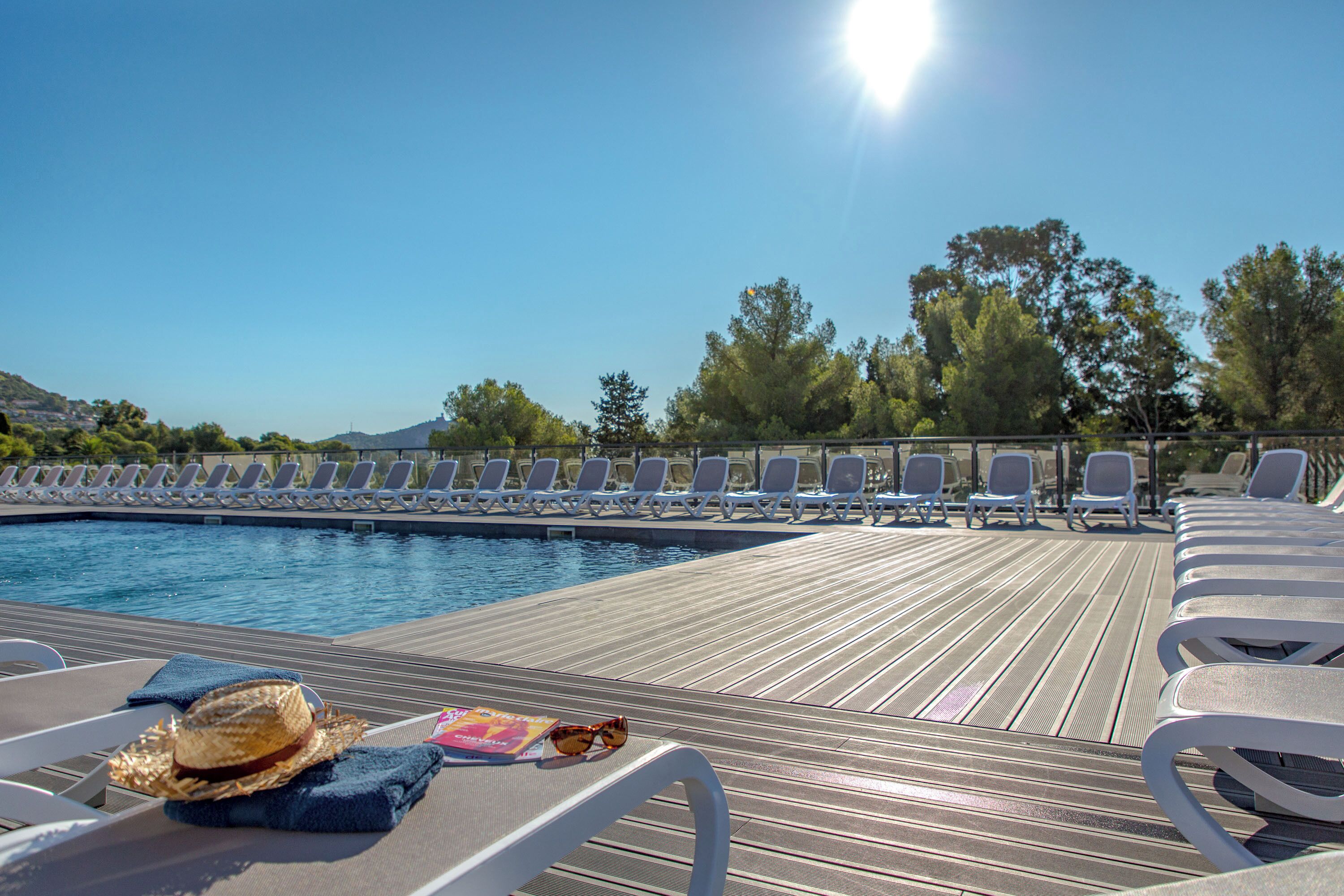 A poolside area with lounge chairs and a pool.