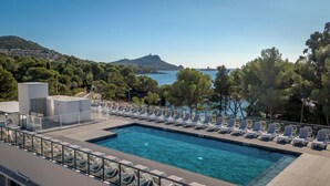 A pool with lounge chairs and a view of the sea and hills. - Appart Abordable pour 4 | Accès Piscine (Saint-Raphaël)