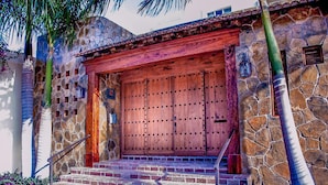 Un bâtiment en pierre avec une porte en bois et des marches menant à l’entrée.