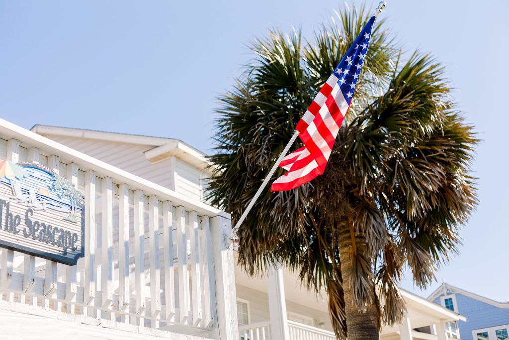 A building with a white fence and a sign that reads "The Seascape."