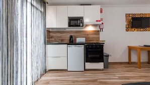 Une cuisine moderne avec des meubles blancs, un four à micro-ondes, un grille-pain et un lave-vaisselle.