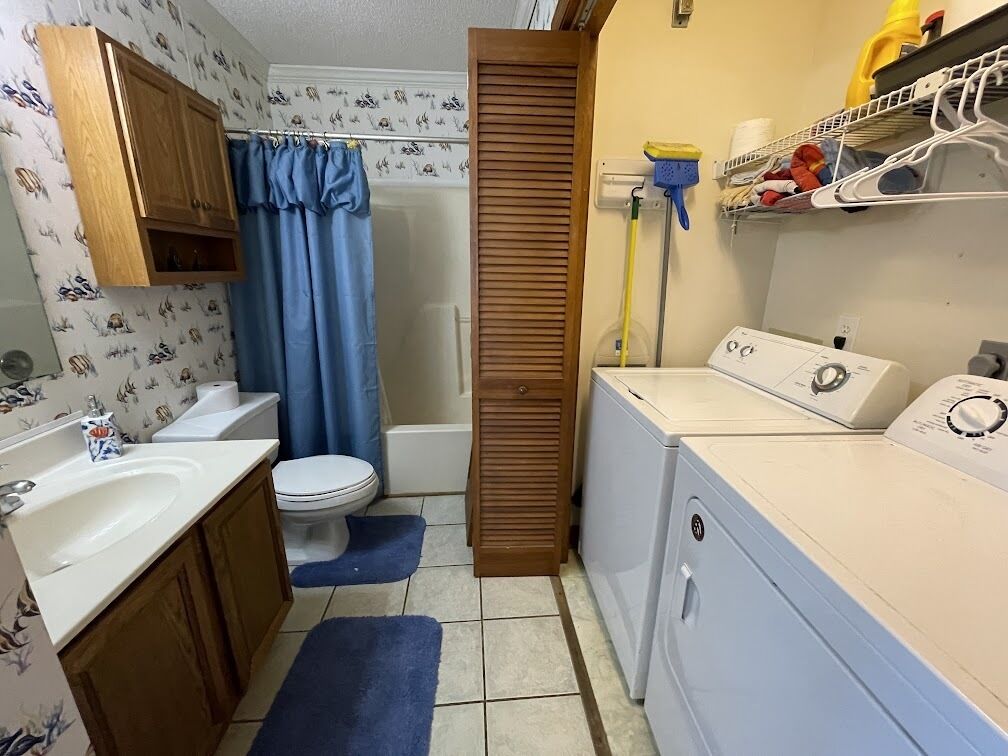 Un baño pequeño con inodoro, lavamanos y lavadora.