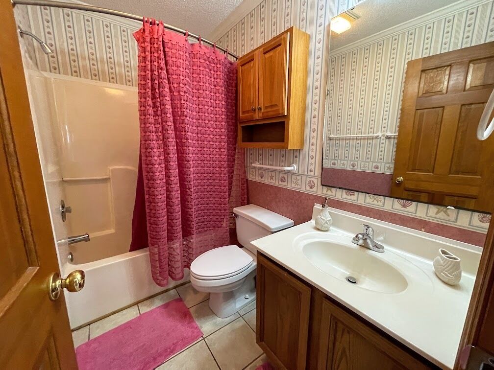 A bathroom with a bathtub, toilet, and sink.