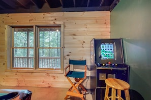 Relax in comfort with a view of the surrounding trees from the large window, and enjoy entertainment options like a classic arcade game.