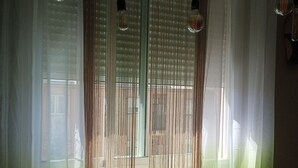 Een kamer met een glazen tafel, geweven zitzakken en een stoel.