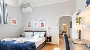 Une chambre d’hôtel moderne avec un grand lit, un bureau et une vue sur le couloir.