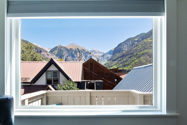 A window view of a mountain landscape with houses. - Charming South Oak Treehouse by Lodging In Telluride | Heart of Telluride Town & walk to ski (Telluride)