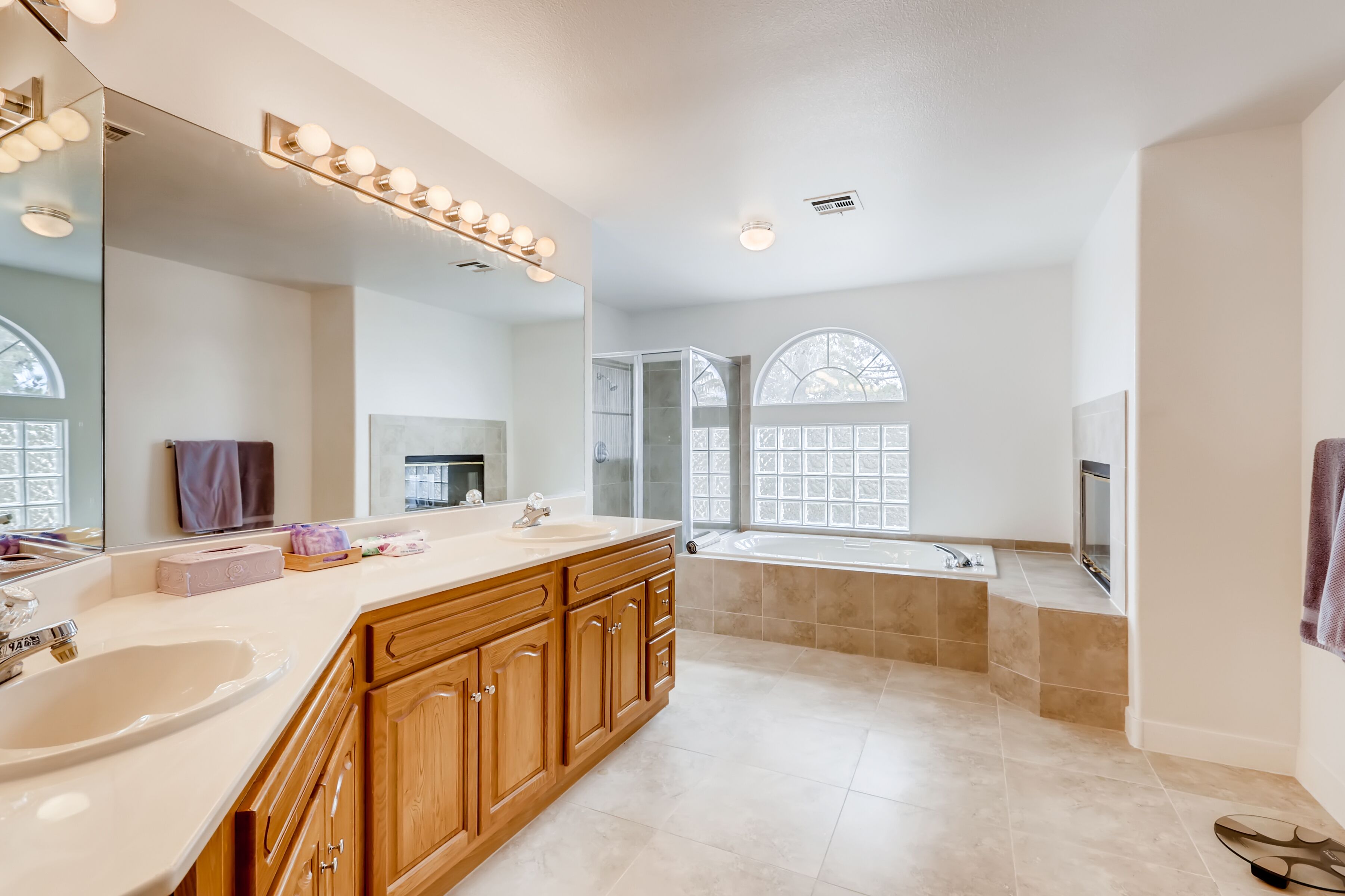 A spacious bathroom with a large vanity, a bathtub, and a walk-in shower.