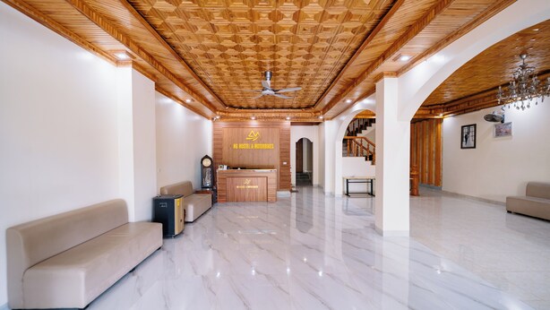 A spacious hotel lobby with a wooden ceiling, a reception desk, a sofa, and a chandelier. - HG Hostel and Motobikes (Ha Giang 1)