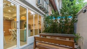 A modern kitchen with sliding glass doors, a wooden bench, and potted plants.