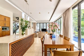 A modern kitchen with wooden cabinets, a built-in oven, and a large window.