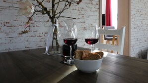 A dining table with two wine glasses, a vase with flowers, and a bowl of bread. - FeWo Frank Rudersberg, 1-3 people, (Rudersberg)